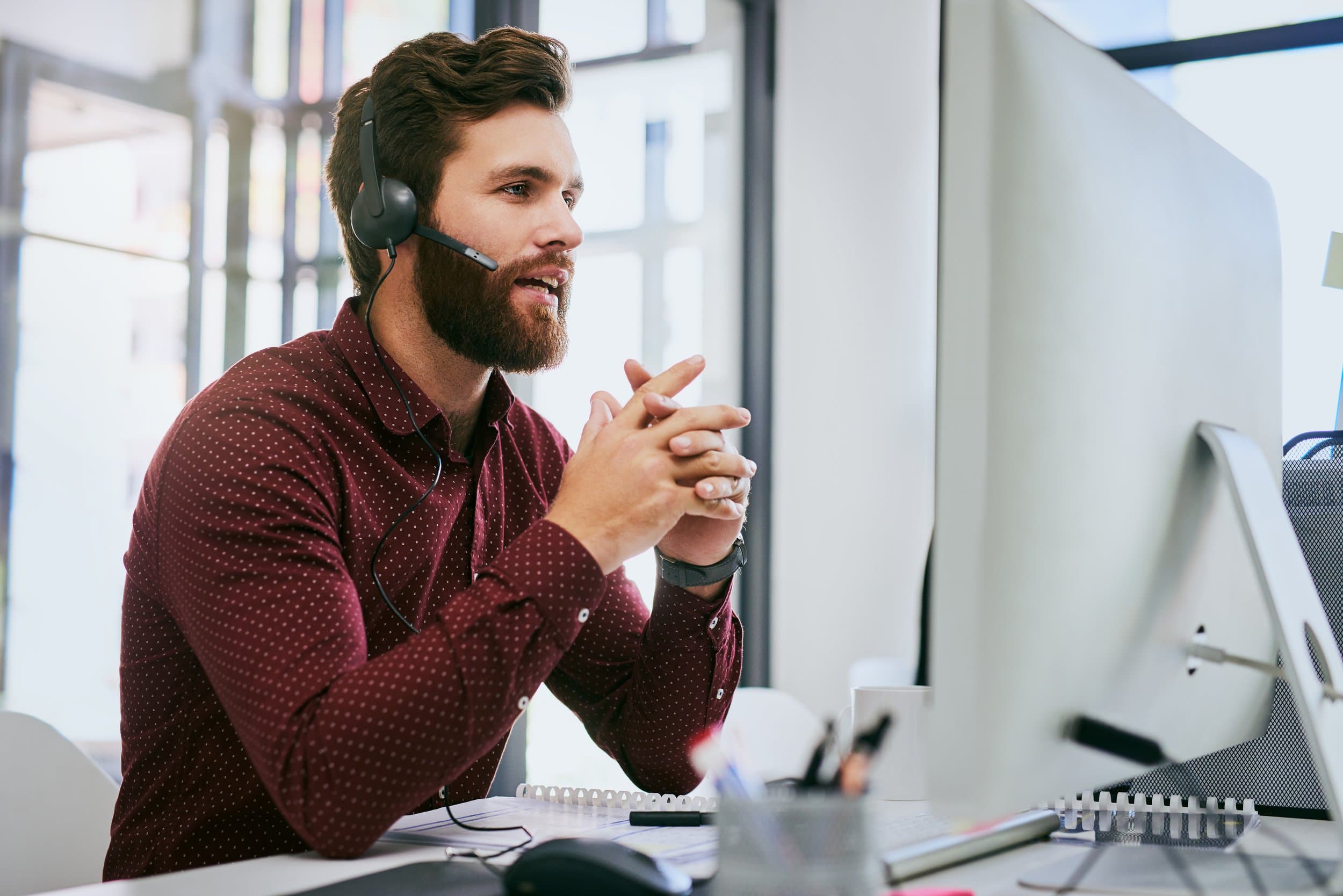 A support consultant helping a client from his desk